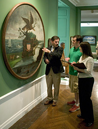 Paul, Cameron, and Mehna discuss a painting