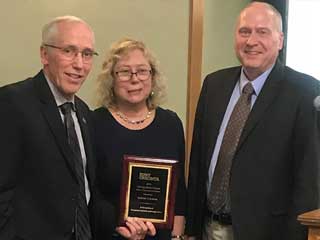 Provost James Mackin (left) and Dean Wade Thomas (right) congratulate Dr. Izabella Lokshina (center) upon receiving the Distinguished Scholar Award 